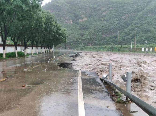 北京暴雨，多区出现水浸，河道旁的道路亦被冲毁。