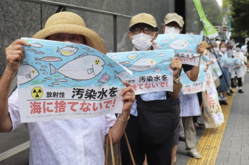 日本民众手持不要将污染水扔进大海等标语在东京电力公司总部前集会抗议。