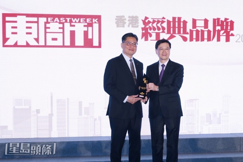 特首李家超（右）颁发「百年经典品牌」大奖给「香港中华煤气」，并由中华煤气企业事务总监杨松坤（左）代表领奖。