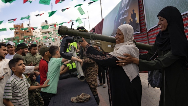加沙巴勒斯坦妇女在努赛拉特难民营的哈马斯武器展上试揸武器。 美联社