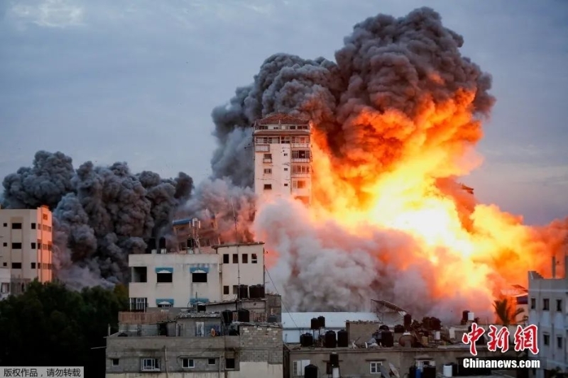 资料图：当地时间10月7日，在以色列军队袭击加沙城内一座高楼后，现场火光冲天浓烟滚滚。