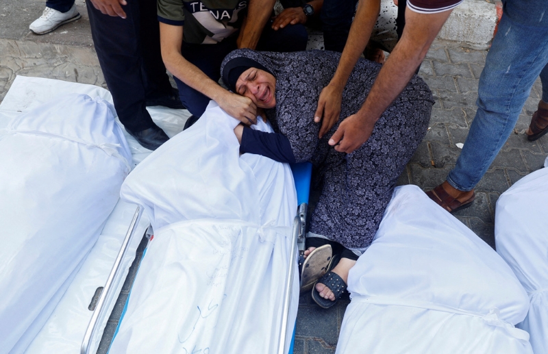 以色列连日强力空袭加沙走廊，居民死伤惨重。 一名妇人11日在加沙走廊一家医院外抚尸痛哭。 （路透）
