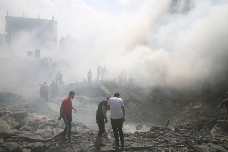 以色列12日空袭加沙走廊南部难民营后，当地巴勒斯坦人四处寻找幸存者。