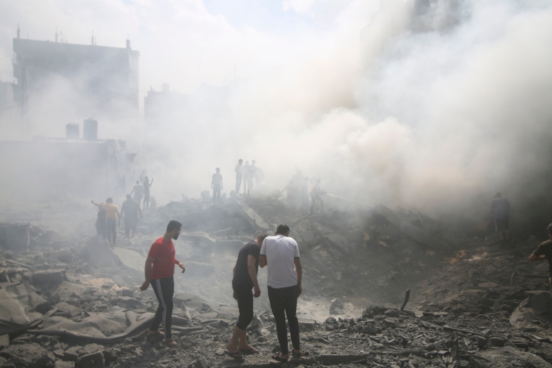 以色列空袭加沙南部难民营后，当地巴勒斯坦人四处寻找幸存者。