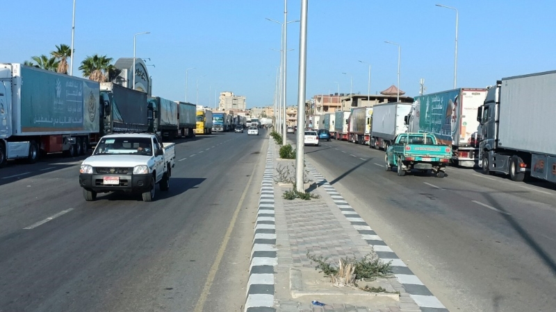 运载大量人道救援物资的多架大货车正等待通过拉法关口，开入加沙。 美联社