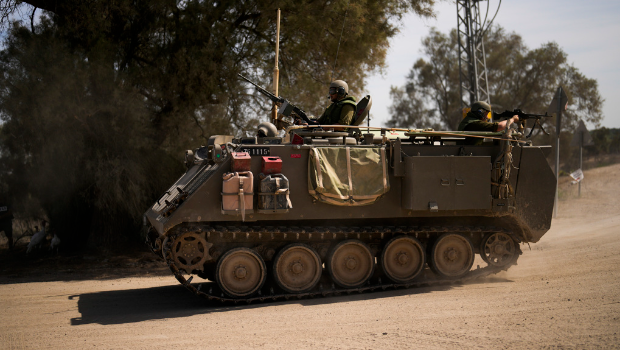 图为以色列士兵在以色列和加沙走廊边境附近驾驶军车。