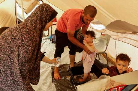 加沙南部汉尤尼斯市躲在由联合国运营的帐篷营地避难的巴人正在为孩子洗澡。 路透社