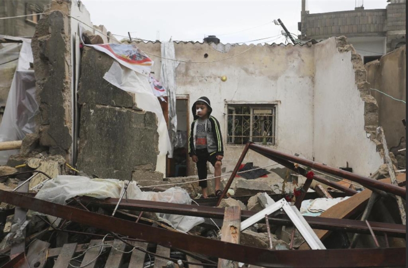 一名巴勒斯坦儿童14日在以色列空袭后看着废墟。美联社