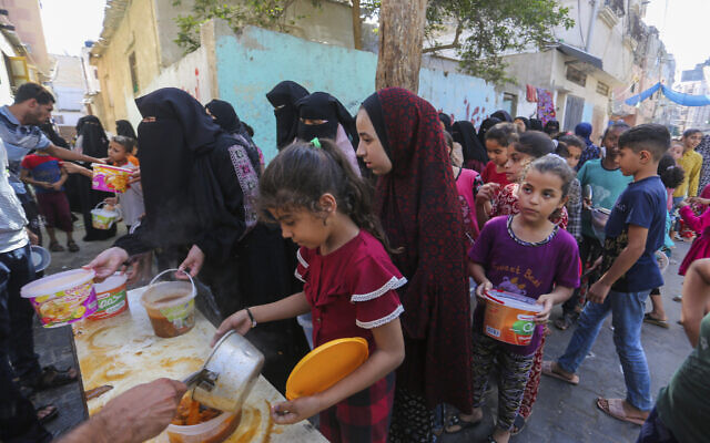 加沙南部拉法市居民排队领取食物。 美联社