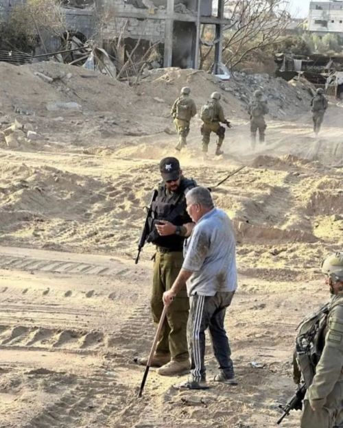 以军拍摄了这张在加沙《扶老人过马路》照片。