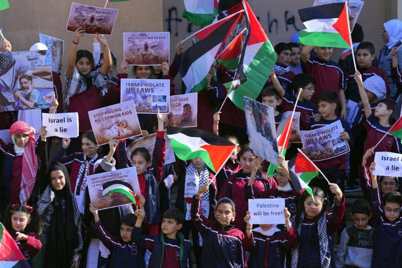 在黎巴嫩贝鲁特联合国西亚经济社会委员会总部前，学生们举着横额和巴勒斯坦国旗，抗议以色列对加沙的轰炸。AP