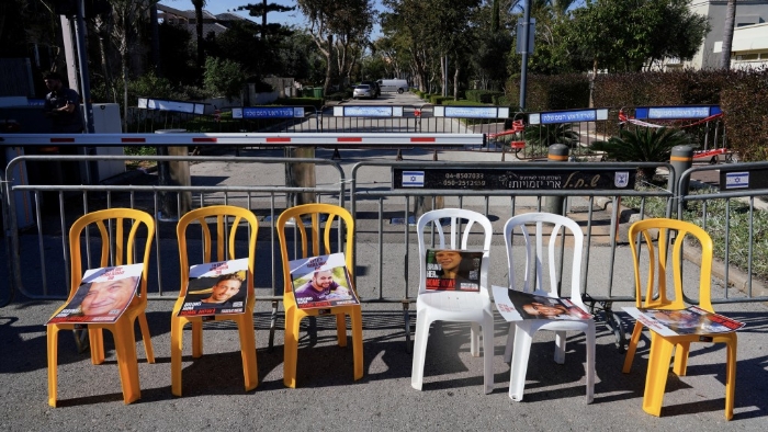 人质家属及支持者在空凳上放人质肖像海报以示抗议。