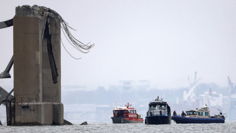 救援船在失去桥面的桥墩旁工作。 路透社
