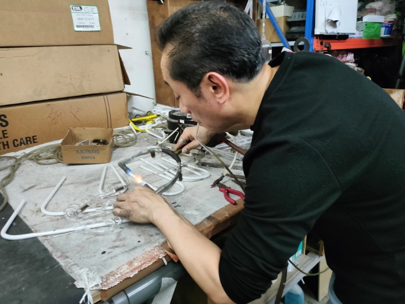 胡智楷师傅开始进行最后的镶焊电极及抽真空工序