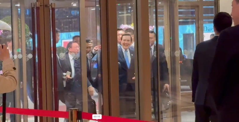 马英九在众人搀扶下走进饭店大门。