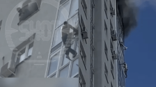 俄罗斯高楼大火，男子爬墙逃生当众摔死，另1人悬窗捡回一命