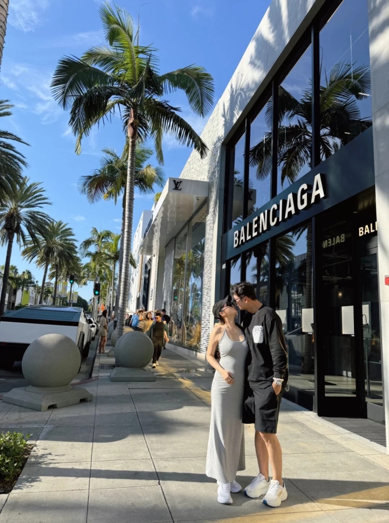 高钧贤与女友在街头甜蜜咀嘴，他女友皮肤非常白皙且身材高䠷。 她身穿灰色贴身吊带连身裙配白波鞋，用了右手遮肚凸凸的肚子，中指更戴上疑似定婚戒指，孕味浓。