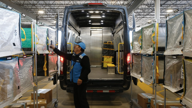 亚马逊送货司机点算及将包裹放上车。