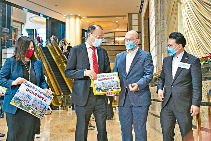 李家超的竞选办副主任陈勇(右一)和谭志源(右二)接收团体的建议书。