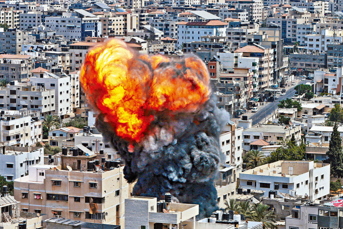 加沙地带一处建筑物昨遭以军空袭后，冒出火焰和浓烟。