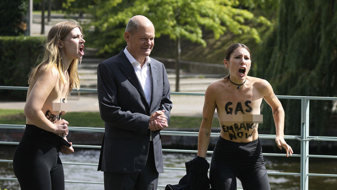 德国总理朔尔茨遇两名女子脱衣抗议，要求禁运俄罗斯天然气。 AP