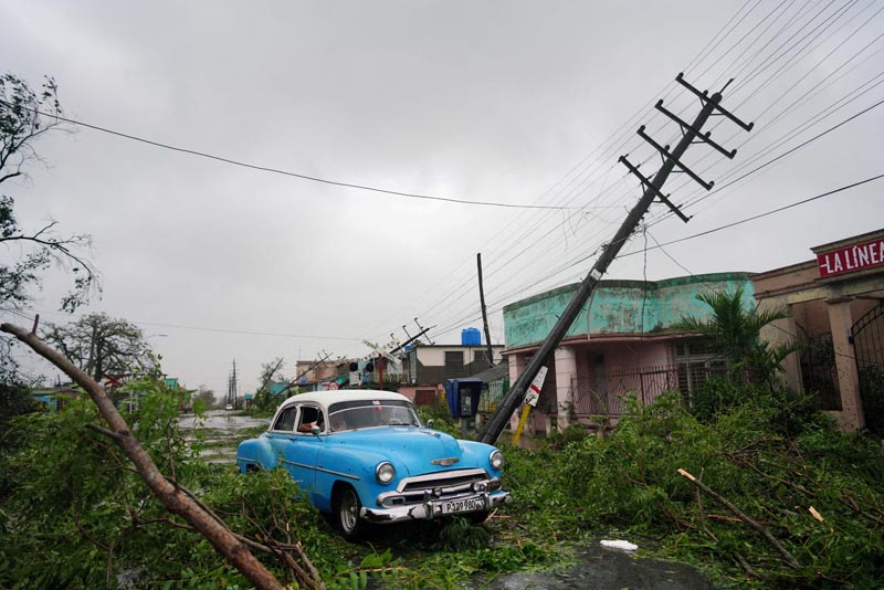 2022年9月27日，一辆老爷车在古巴比那尔德里奥经过时，被飓风伊恩造成的碎片所经过。路透社 1111