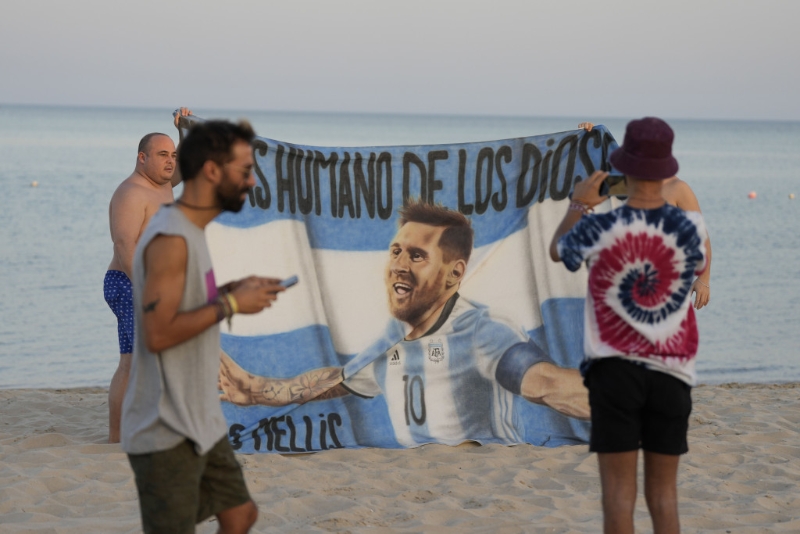 球迷在沙灘展示美斯橫額。 AP