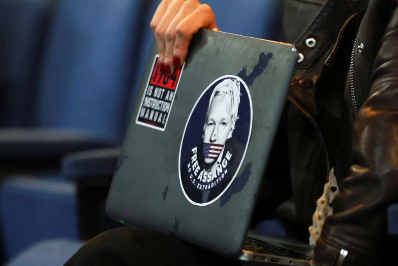 波哥大国立大学一位女士拿着一台电脑,上面贴着写着释放亚桑杰的贴纸。(路透社)