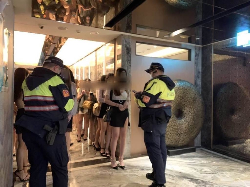 北市大安警分局臨檢比基尼辣妹酒店，藉此宣示維護治安的決心。滿場辣妹穿梭，員警害羞不敢直視。（翻攝畫面）