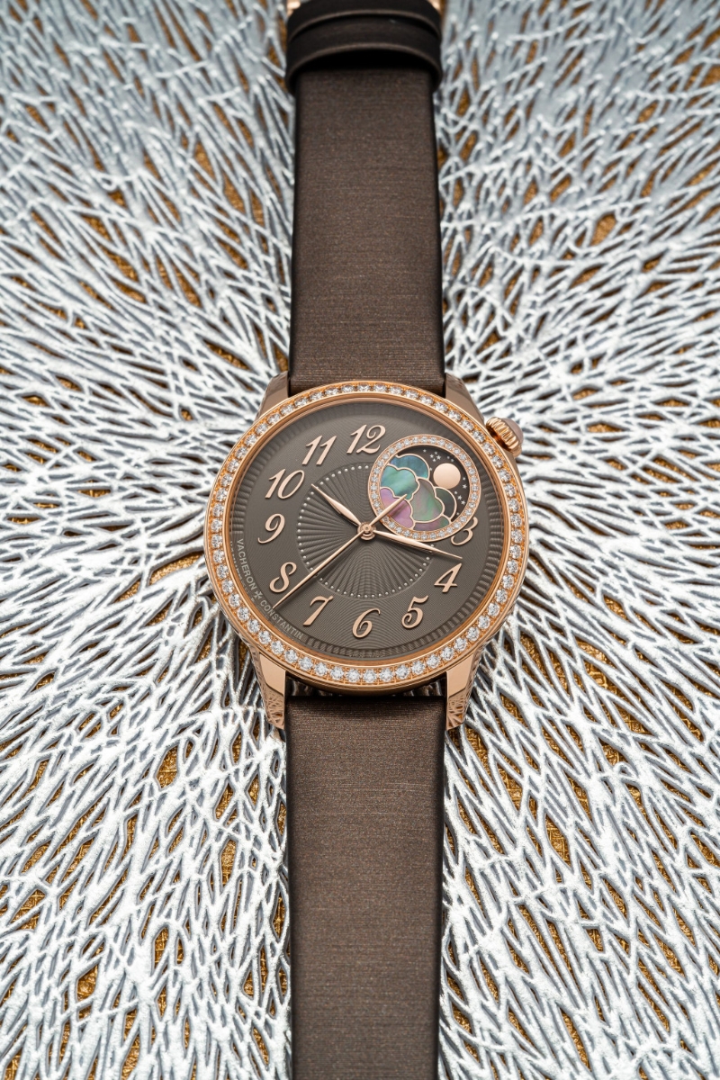 &Eacute;g&eacute;rie moon phase，啡面月相表的表圈镶有58颗钻石，月相环则镶有36颗，数量当然不可与密镶钻石的一款相比，但啡色表盘上有放射加圆环纹理，又有立体阿拉伯数字时刻，月相以粉红金制并配衬母制云层，华丽感同样浓烈，时间显示也更清晰易读。 表冠镶有月长石。 $287,000