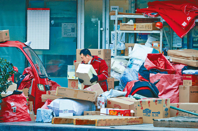 北京快递员，正在整理大量的积压包裹。