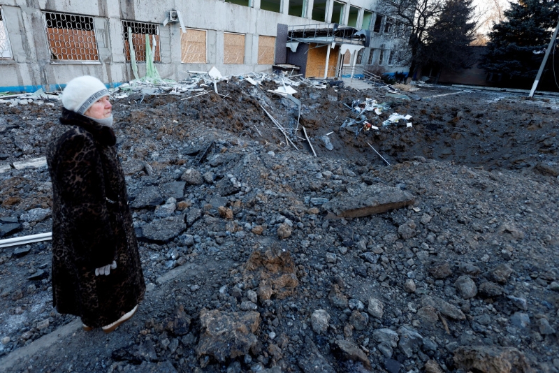 在乌克兰克拉马托尔斯克市，有人在被俄军袭击留下的弹坑前留影。 路透社