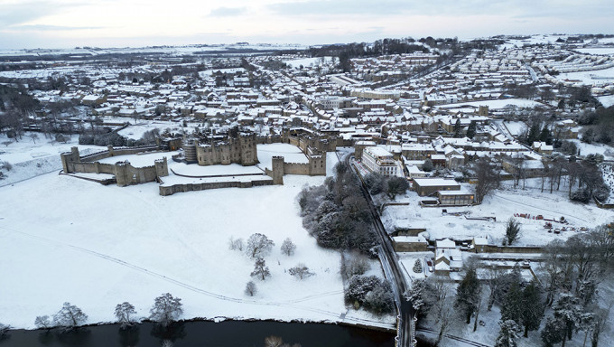 英國各地發布冰雪天氣警告，英格蘭東北部諾森伯蘭郡的阿尼克城堡周圍積雪覆蓋的田野。AP