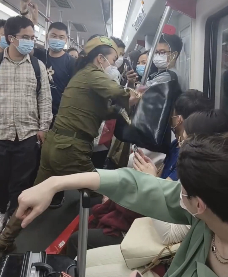 女子将手袋拍向男乘客头部。