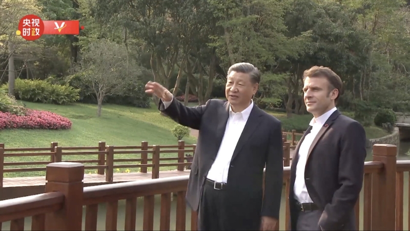 習近平與馬克龍在廣州松園散步。央視截圖