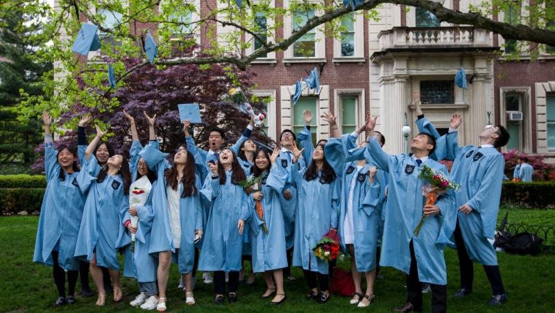 紐約哥倫比亞大學一群華人學生拋帽慶祝畢業。 新華社