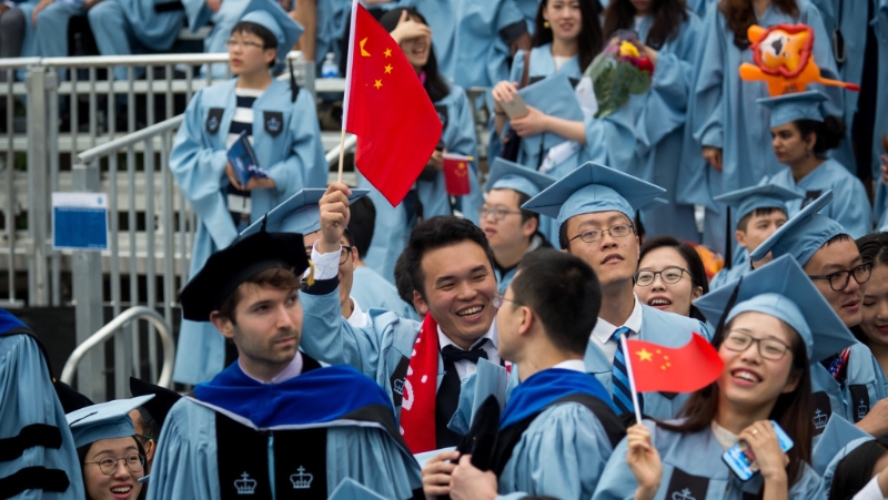 紐約哥倫比亞大學華人畢業生在畢業典禮上揮舞中國國旗。 新華社