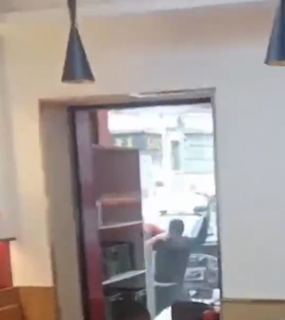 拿刀店员出门口后作势斩人。 微博截图 拿刀店员出门口后作势斩人。 微博截图