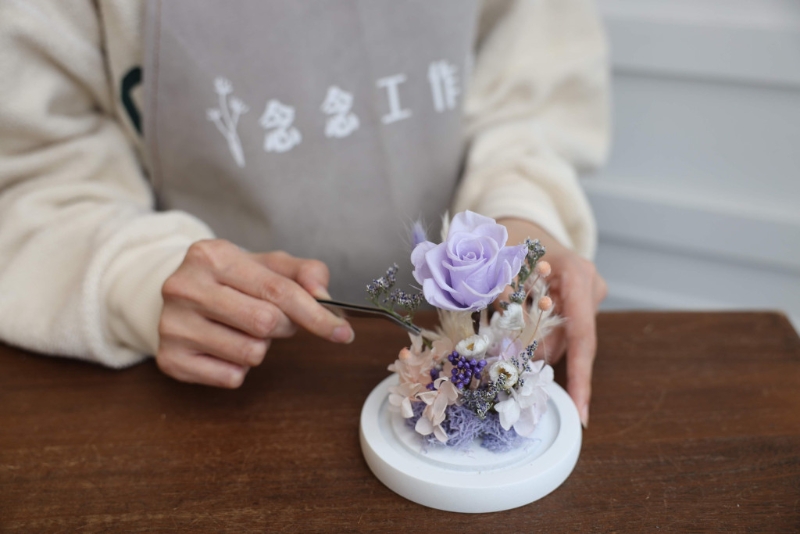 母亲节保鲜花玻璃瓶工作坊/原价$800、优惠价$480，玻璃瓶以保鲜玫瑰作主花，配以粉紫和香槟色保鲜绣球花与配花，保存可达3年，二人同行享9折。 （念念工作室）