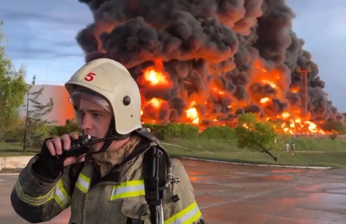 克里米亚储油厂发生大火，一名消防员在对讲机上讲话