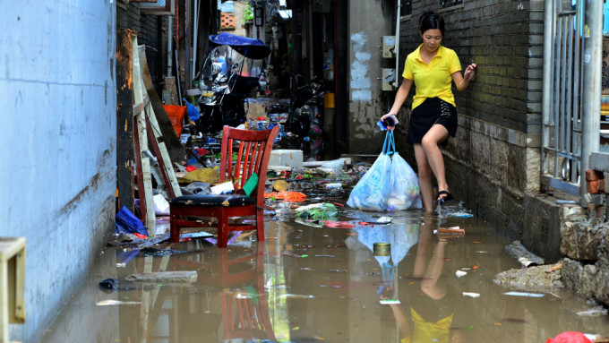 福州市多处水浸马尾区快安村村民涉水出行。
