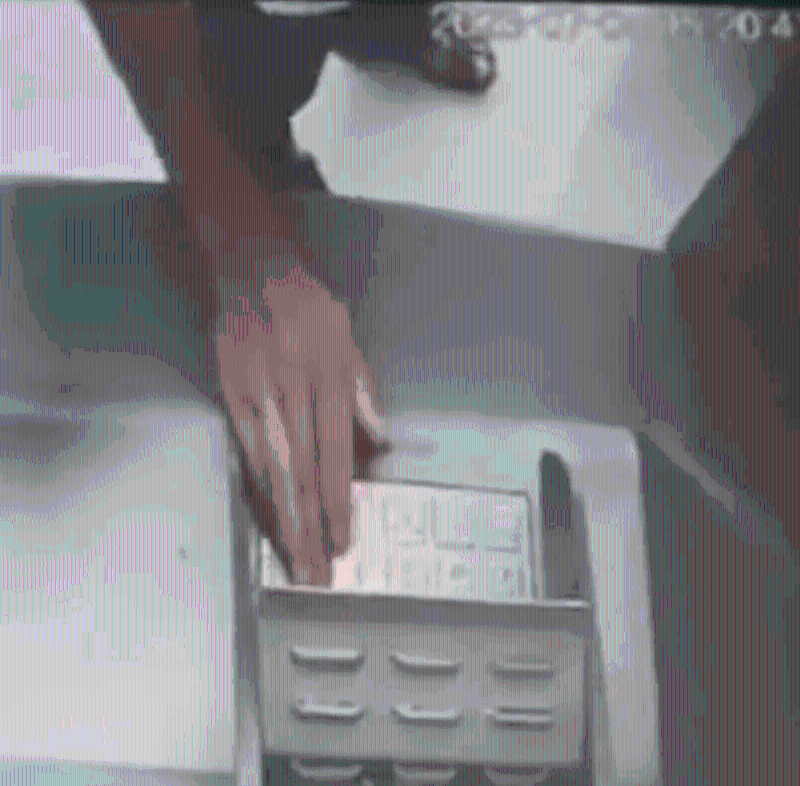 闭路电视拍下男子将一叠阴司纸放入自动柜员机后，在旁边正常的ATM上查看余额。