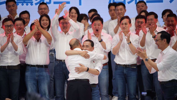 国民党23日举行全代会，2024参选人侯友宜（中前）与前高雄市长韩国瑜（中前背对者）在台上大力拥抱