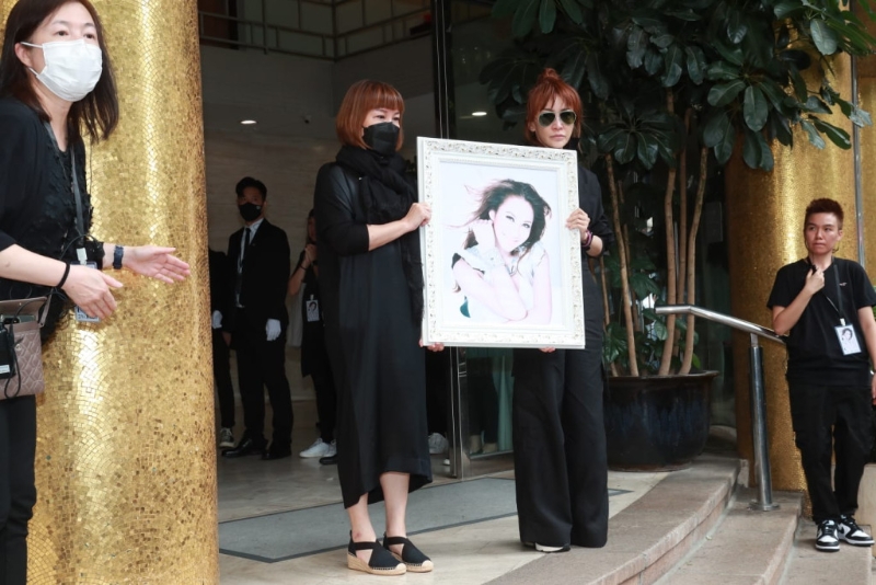 两位姐姐手捧妹妹的遗照 两位姐姐手捧妹妹的遗照