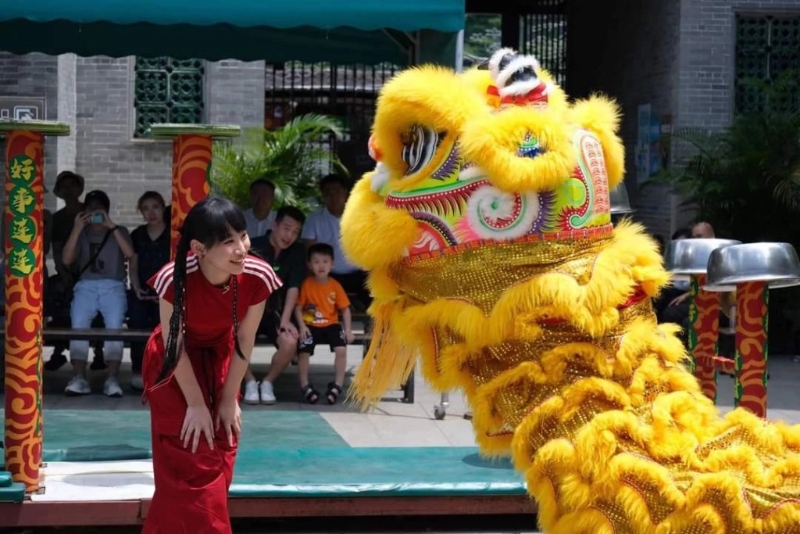 炎明熹到佛山祖庙的舞龙舞狮活动拍摄，与舞狮队成员问好。