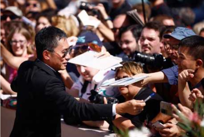 伟仔行红地毯时,不忘为影迷们签名。 伟仔行红地毯时,不忘为影迷们签名。