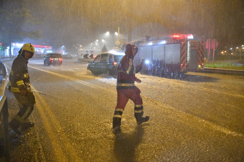 消防员冒着黑雨行动。