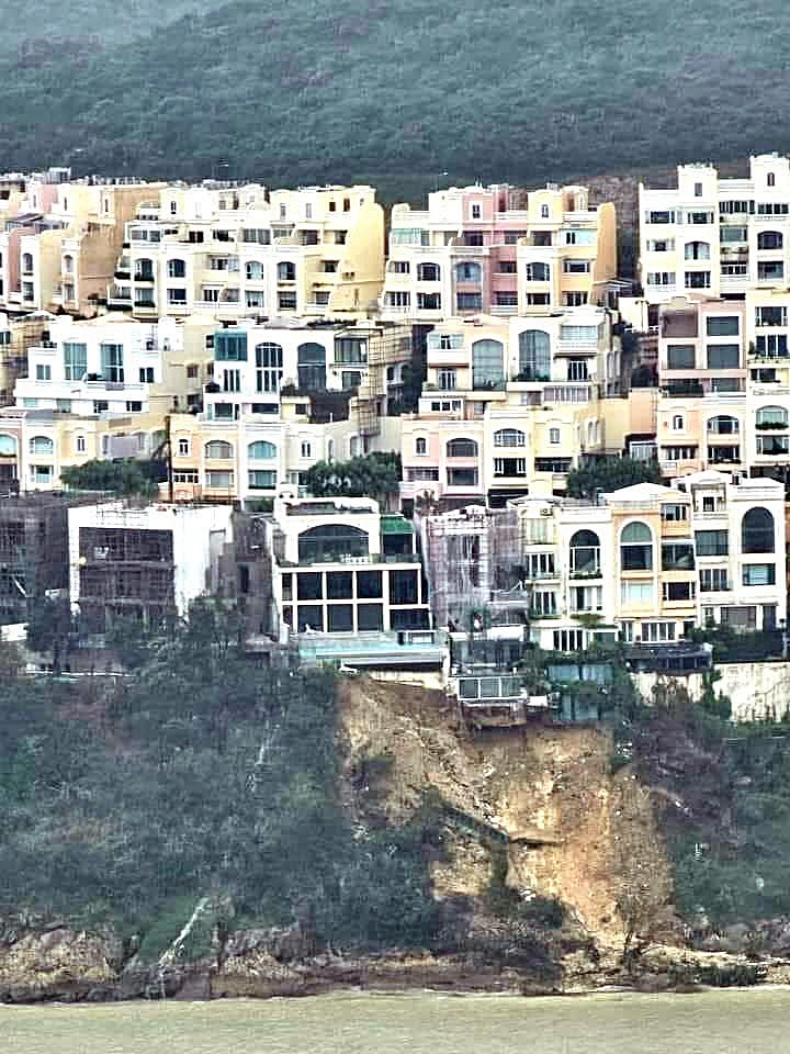 山坡上有建筑物基层暴露悬崖上。