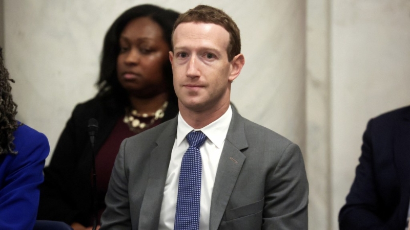 Facebook创办人扎克伯格坐在会议厅内。