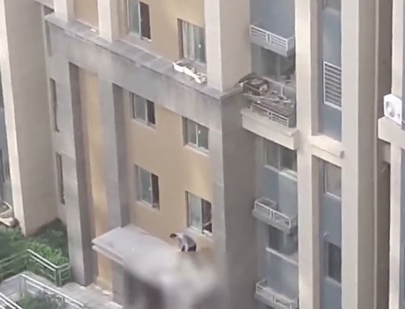 救援人员爬出房檐察看伤者情况。